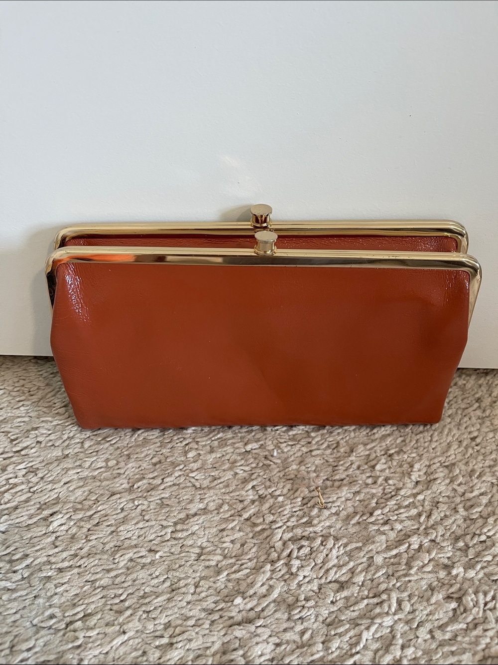 Hobo Lauren Clutch wallet in polished Rust Orange with Gold Trim